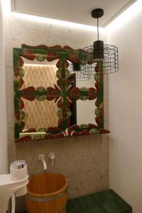 a bathroom with a mirror and a wooden tub at Pensiunea Varvara de Bucovina in Gura Humorului