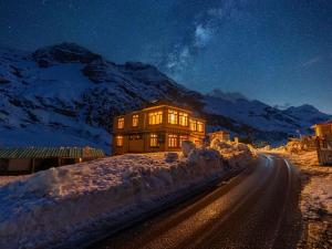 ein Haus in der Nacht mit Schnee am Straßenrand in der Unterkunft Moustache Koksar Luxuria, Sissu in Khoksar