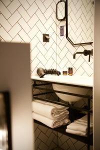 uma casa de banho com lavatório, espelho e toalhas em COQ Hotel Paris em Paris