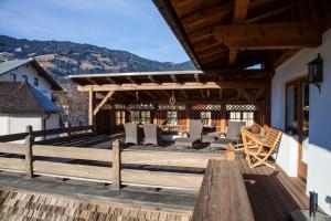 a wooden deck with chairs and a pergola at Appartements Pfister in Fügen