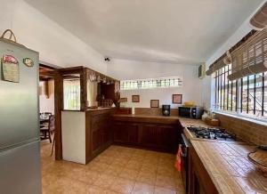 a large kitchen with wooden cabinets and a counter top at Villa Séga in Trou d'Eau Douce