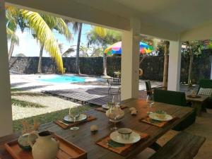 a dining room table with a view of a swimming pool at Villa Séga in Trou d'Eau Douce