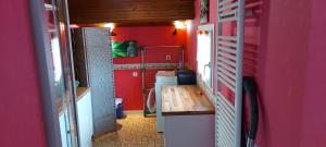 a room with red walls and a table in a house at Maison ZEN climatisée in Commequiers +5 photos