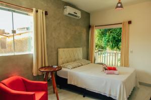 a bedroom with a bed and a chair and a window at Go Pipa INN in Pipa +49 photos