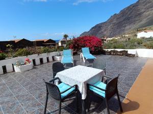 a table and chairs on a patio with mountains in the background at Roque Blanco in Frontera