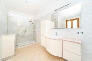a white bathroom with a sink and a shower at Giulio in Campagnano di Roma