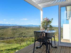a table and chairs on a deck with a view at Plettenvale Wines in Plettenberg Bay
