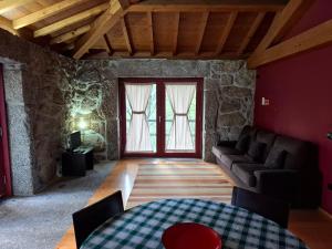 ein Wohnzimmer mit einer Couch und zwei Fenstern in der Unterkunft House 3 in Fafe