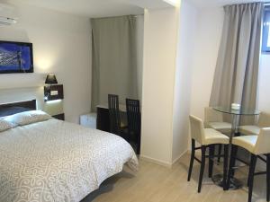 1 dormitorio con 1 cama, mesa y sillas en H Skyline en Alcorcón