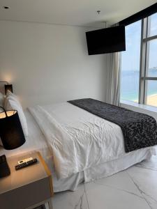 リオデジャネイロにあるHotel Nacionalのベッドとテーブルとテレビのある寝室