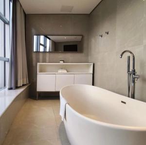 リオデジャネイロにあるHotel Nacionalのバスルーム(鏡付き白いバスタブ付)