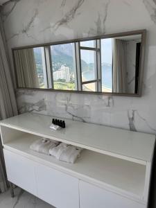 リオデジャネイロにあるHotel Nacionalの白いバスルーム(鏡、白いタオル付)