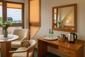 a hotel room with a table and a mirror at Apartamenty i pokoje Chaton Mielno in Mielno