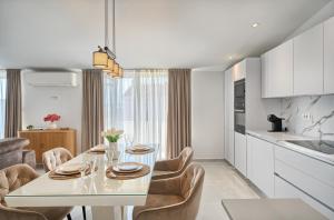 a kitchen and dining room with a white table and chairs at 3rd Floor Apartman in Kaštela