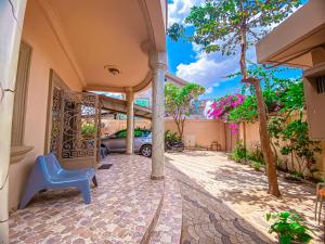 a house with a blue chair in a courtyard at KLEIN Résidence de FAFA in Abomey-Calavi