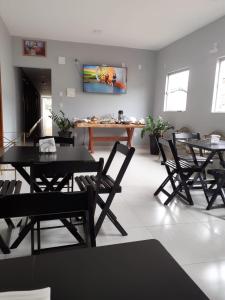 Santa Maria do SuaçuíにあるHotel Avenidaの黒いテーブルと椅子のあるダイニングルーム