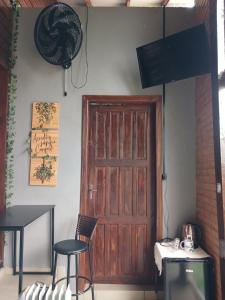 a room with a door and two chairs and a table at Espaço Ravenala próximo aeroporto in Chapecó