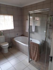 a bathroom with a bath tub and a toilet at Mountains and More in Hekpoort +39 photos