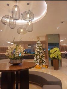 Un vestíbulo con un árbol de Navidad, una mesa y luces. en Pasay Mall of Asia Shore1 Residences Tower C2, en Manila