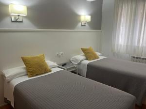 A bed or beds in a room at Pensión Lizaso