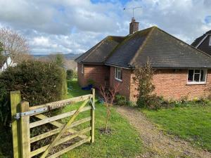 een houten hek voor een huis bij Oakleaves in Lodsworth +1 foto
