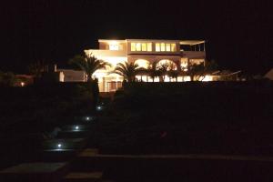 uma grande casa branca à noite com luzes em Apartments puntaplanka direkt am meer em Razanj