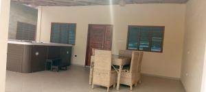 a room with a table and chairs and windows at Maison Porto-novo in Aboga