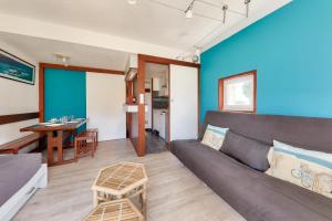 a living room with a couch and a table at Idéal 4 adultes et 1 enfant à 300m de la plage in Arzon