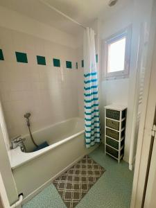 a bathroom with a tub and a sink at Maison rêv'etang, Cayeux-sur-Mer, Baie de somme in Cayeux-sur-Mer