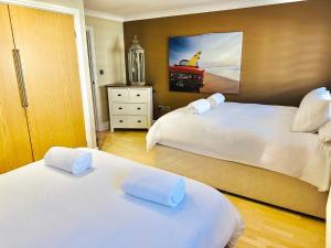 a bedroom with two beds and a painting on the wall at Brecon Beacons Welsh Countryside Retreat in Merthyr Tydfil
