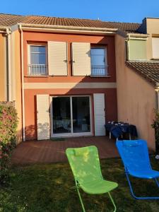two green and blue chairs in front of a house at Maison rêv'etang, Cayeux-sur-Mer, Baie de somme in Cayeux-sur-Mer