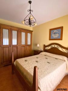 a bedroom with a bed and a chandelier at La Golondrina in Cáñar