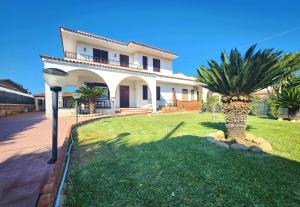 a house with a palm tree in front of it at Villa Charlene in Terrauzza