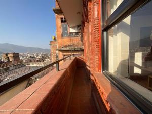 a balcony with a bench on top of a building at Tehra Family Building in Kathmandu