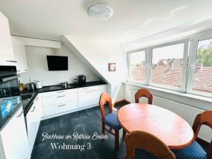 a kitchen with a wooden table and a table and chairs at Bachhaus am Rathaus 3 in Emden