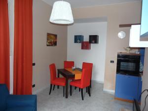 una sala da pranzo con tavolo e 4 sedie rosse di Home Sweet Home a Napoli