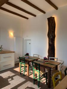 a dining room with two wooden tables and green chairs at Agriturismo Parco della Chiusa in Casalecchio di Reno