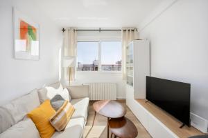 a living room with a white couch and a flat screen tv at Amazing 3bdr Apt In Cornella 1 Mins From Metro in Cornellà de Llobregat