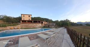 a swimming pool with lounge chairs and a building at LA CEGNA in Montemaggio +70 photos