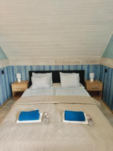 a large bed with two blue pillows on it at Sailor's Apartman in Siófok