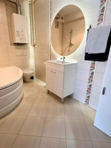 a bathroom with a toilet and a sink and a mirror at Makas Apartamenty in Świnoujście
