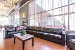 a living room with a leather couch and a table at Quality Inn & Suites Bell Gardens-Los Angeles in Bell Gardens