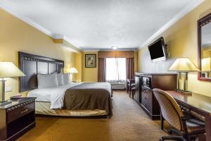 a hotel room with a bed and a desk at Quality Inn & Suites Bell Gardens-Los Angeles in Bell Gardens