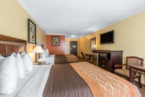 a hotel room with two beds and a television at Quality Inn & Suites Bell Gardens-Los Angeles in Bell Gardens