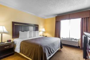 a hotel room with a large bed and a window at Quality Inn & Suites Bell Gardens-Los Angeles in Bell Gardens
