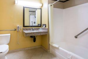a bathroom with a sink and a toilet and a mirror at Quality Inn & Suites Bell Gardens-Los Angeles in Bell Gardens