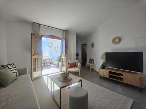 a living room with a couch and a flat screen tv at AP417 Los Mandarinos in El Molino