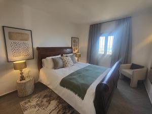 a bedroom with a large bed and a chair at AP417 Los Mandarinos in El Molino +28 photos