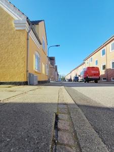 an empty street with a yellow building and a red truck at Double room 6 with Free Parking in Nørresundby