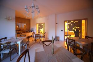 a dining room with tables and chairs and a chandelier at Willaria Country House in Cursi